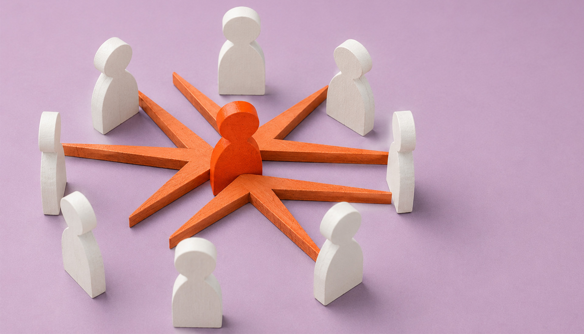 Wooden figures of people arranged in circle around the Miller Thomson spark with an orange figure in the middle
