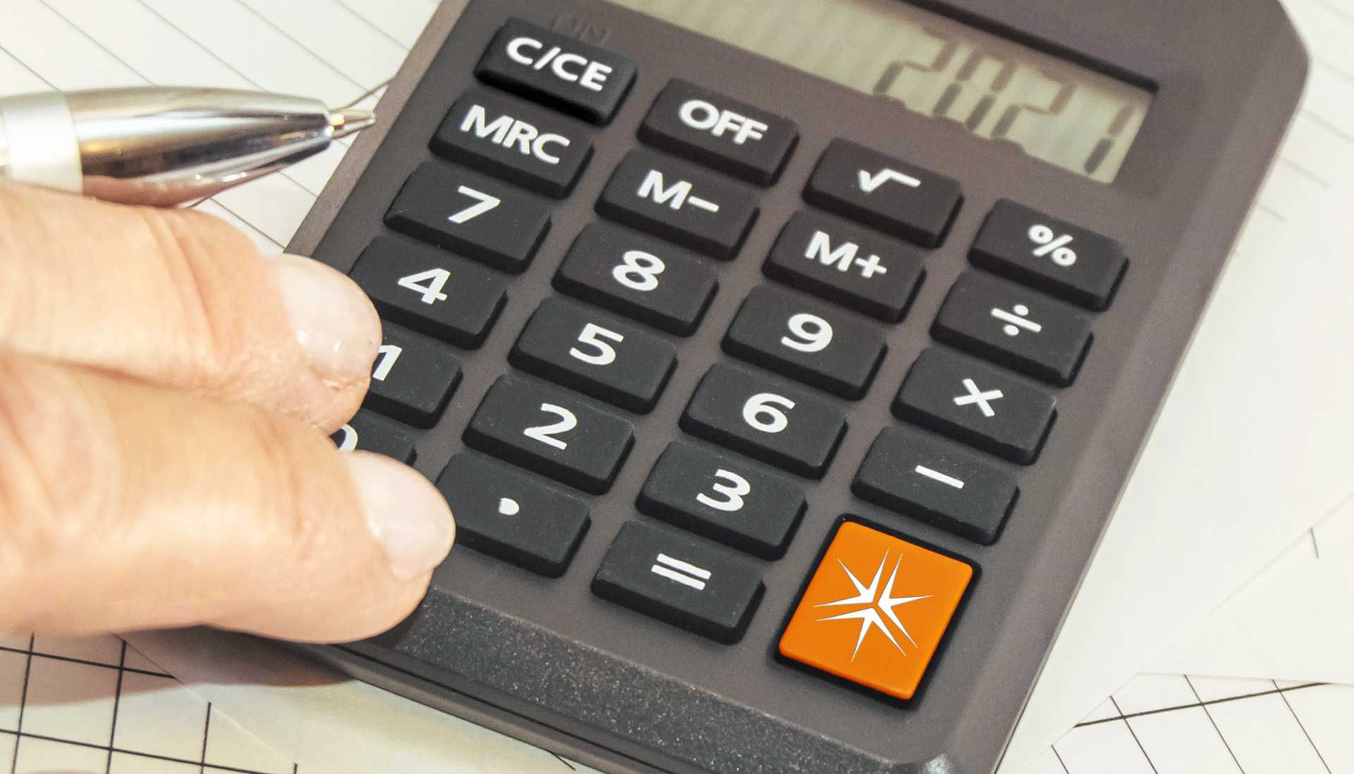 closeup of a man's hand using a calculator. There is large orange button with the Miller Thomson spark.