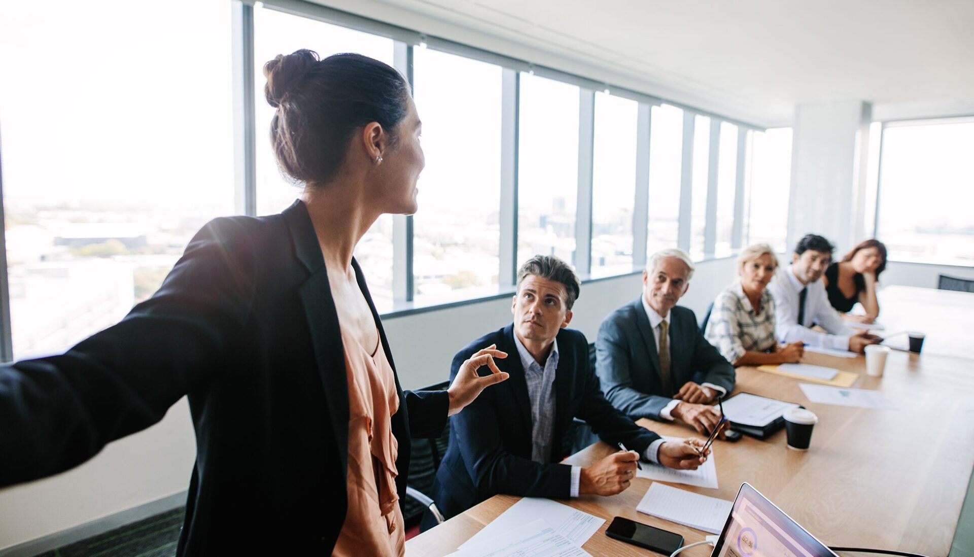 Woman standing at the front of a conference room leading a meeting