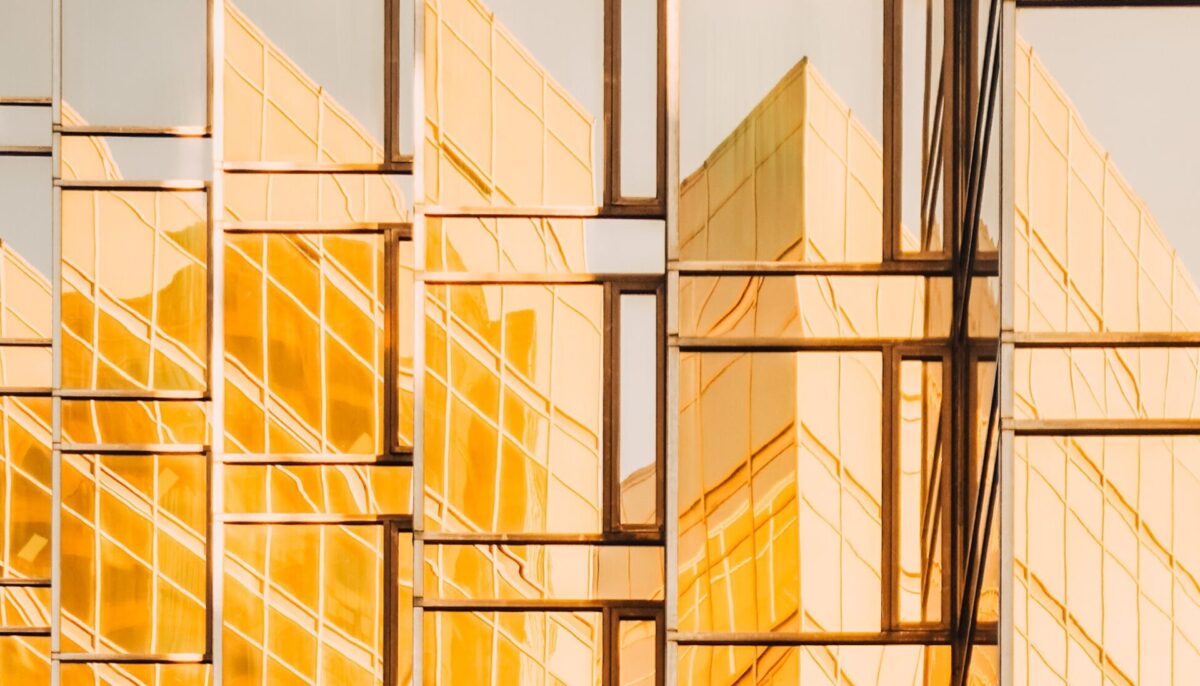 reflection of buildings in a highrise tower window