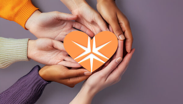 group of multi-ethnic people extending their hands into the centre of a circle