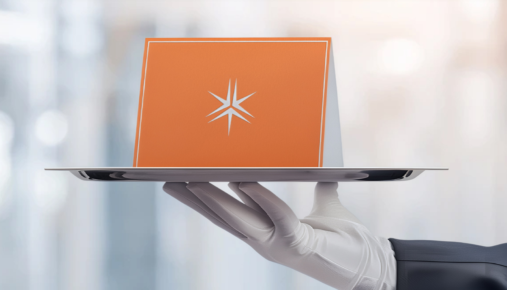service worker wearing a white glove holds up a silver tray with a note card printed with the Miller Thomson spark