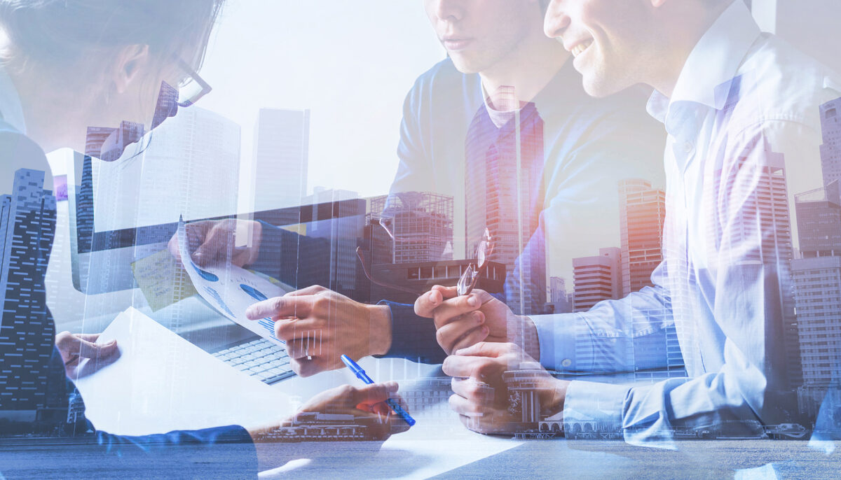 group of people in a meeting overlaying highrise office buildings