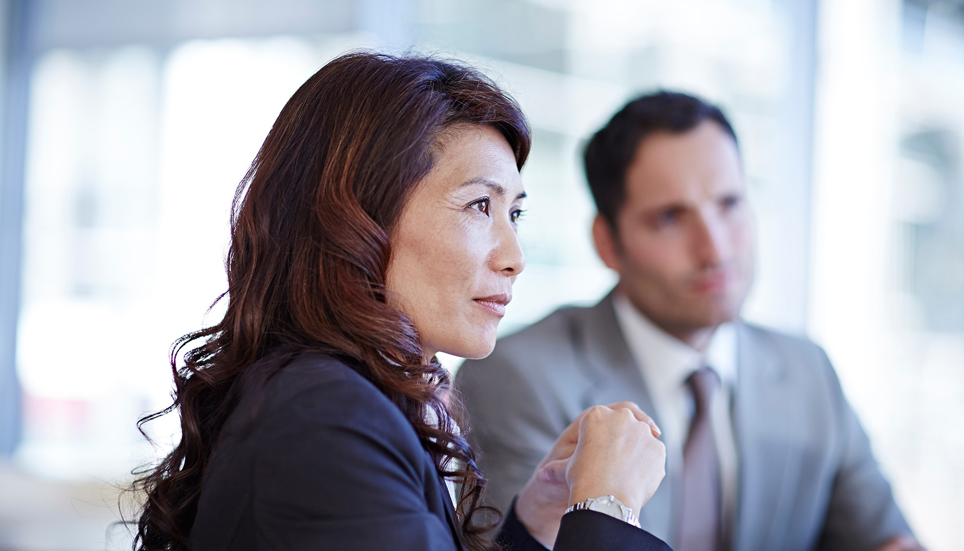asian woman in a suit having a business meeting with male colleague