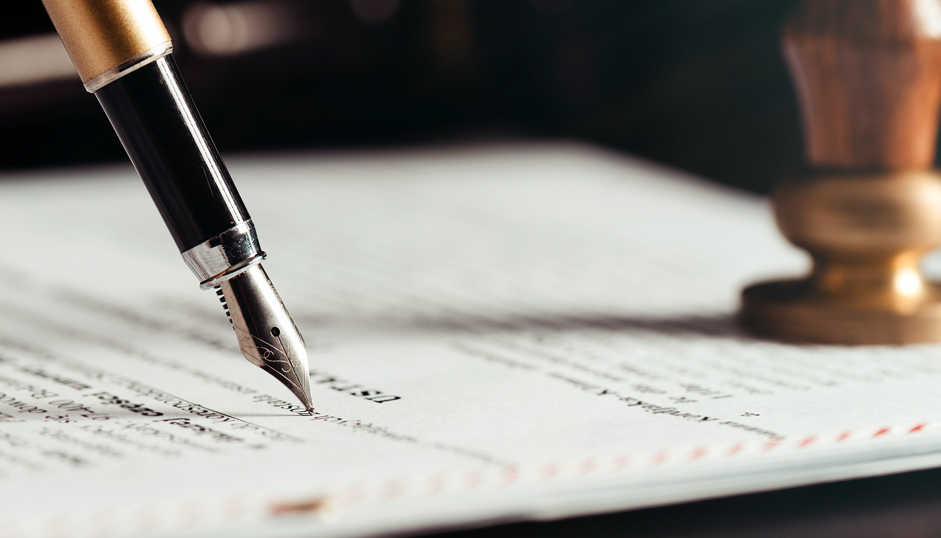fountain pen making notations on legal document with notary stamp in the background