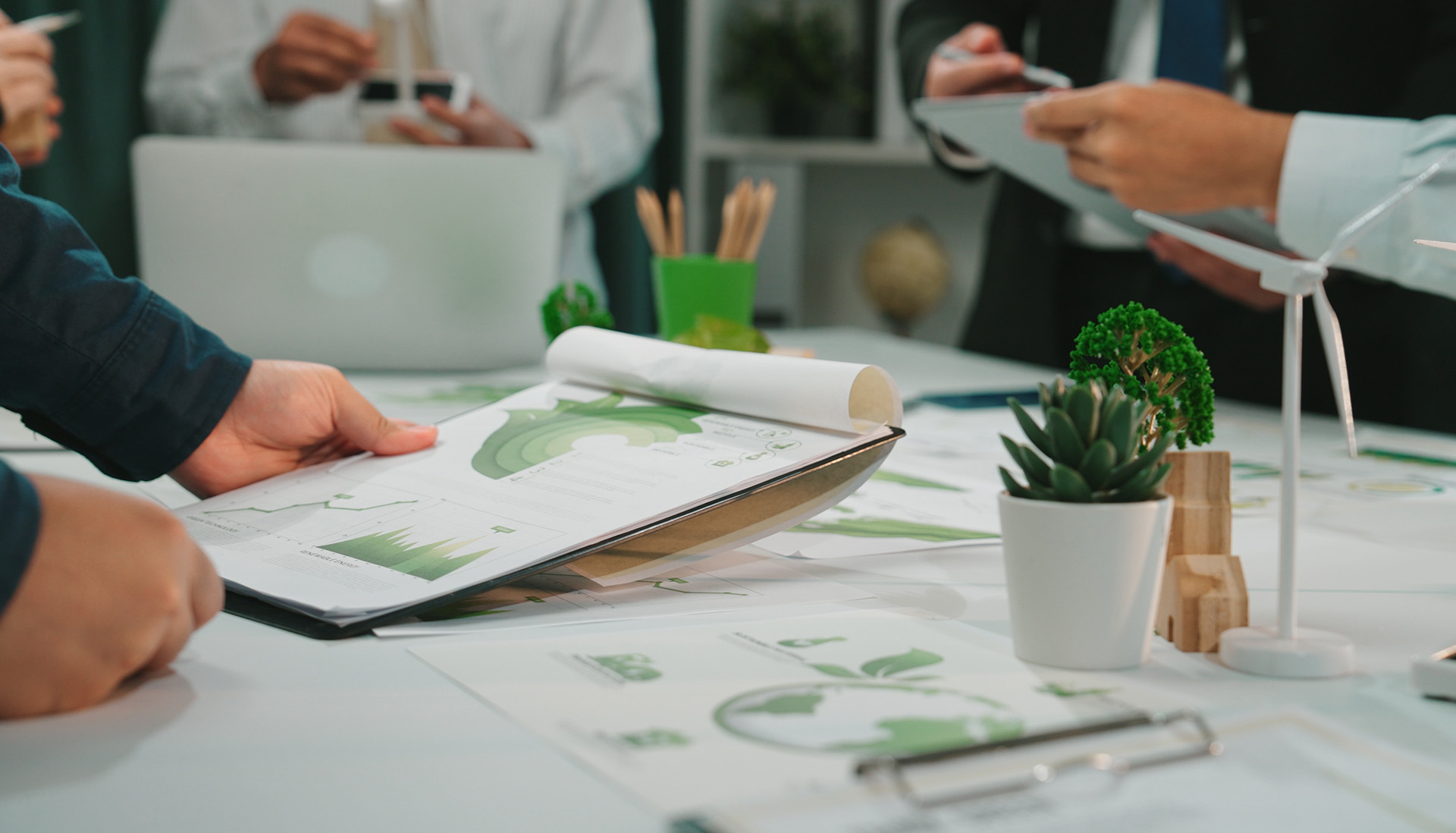 Engaging scene of a business meeting focusing on financial reports and sustainability strategies, showcasing teamwork and collaboration in a modern workspace.