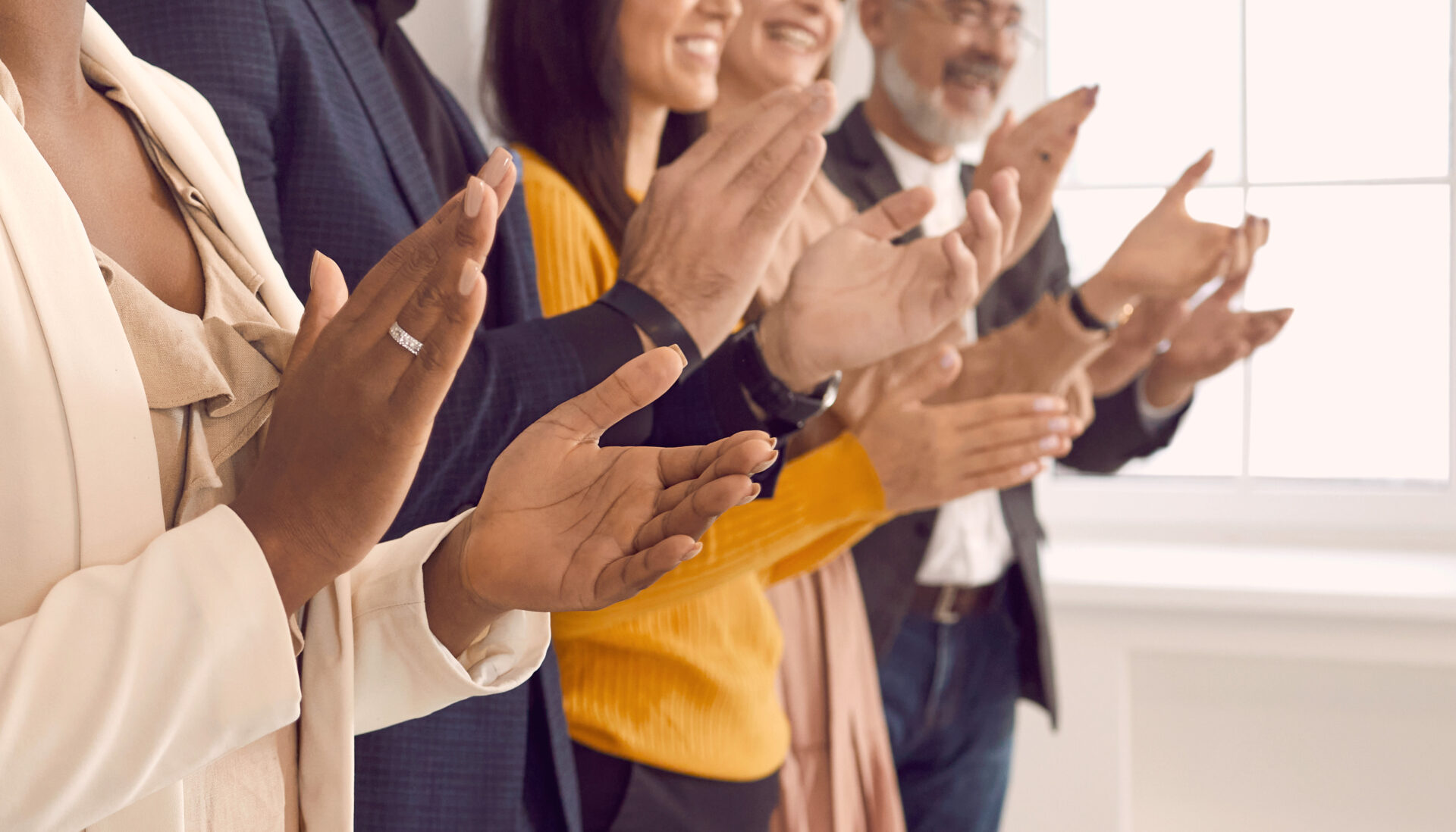 group of people standing up and applauding