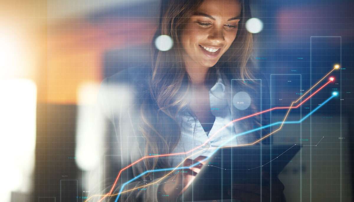 Smiling business woman holding tablet with overlay of stock graphs
