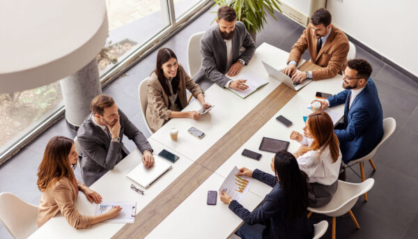 boardroom meeting with eight colleagues sitting around the table