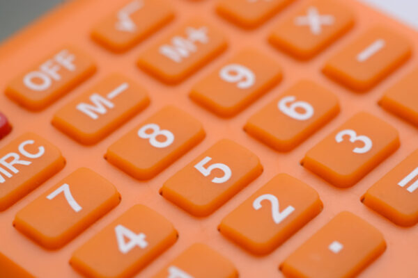 Close-up of an orange calculator with white numbers and function keys.